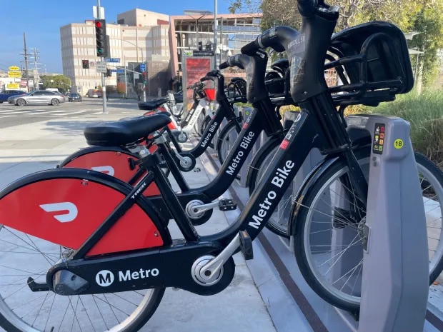 Una ordenada fila de bicicletas de Metro Bike Share encajadas en una estación de bicicletas compartidas.